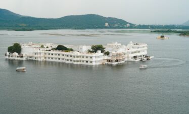 a large white building sitting on top of a lake