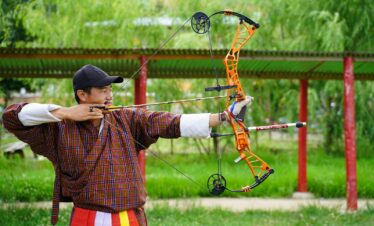 a man is holding a bow and aiming it