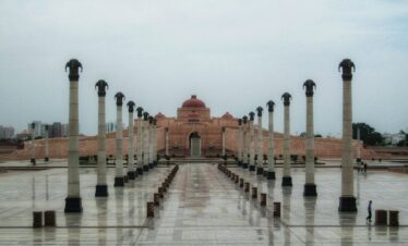 A large building with columns and a clock tower in the background