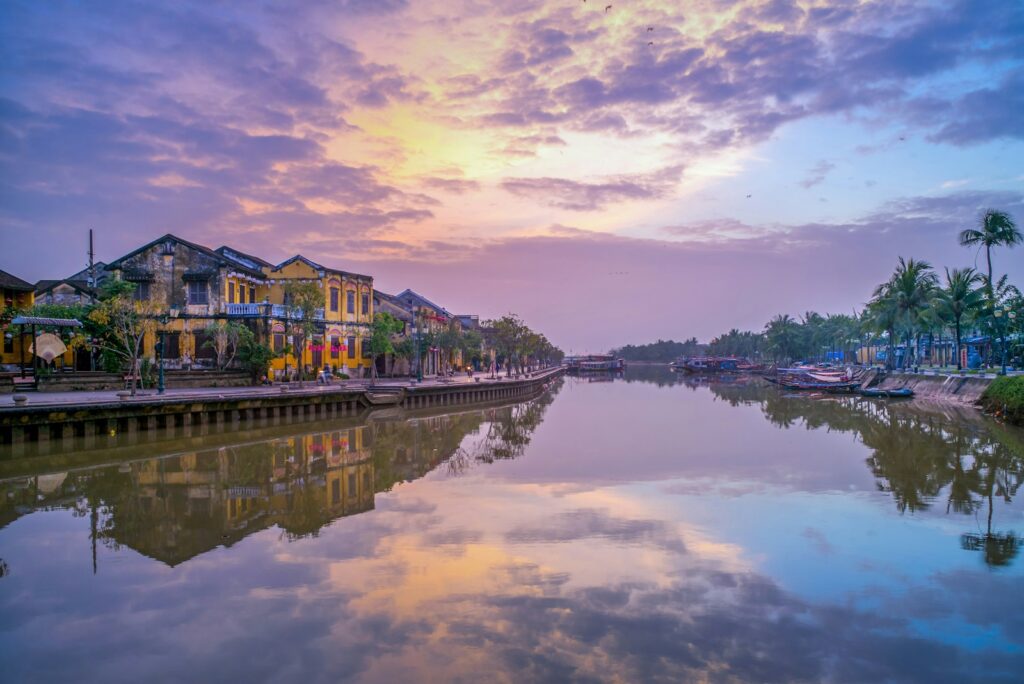 Current image: brown and green house near body of water under cloudy sky during daytime